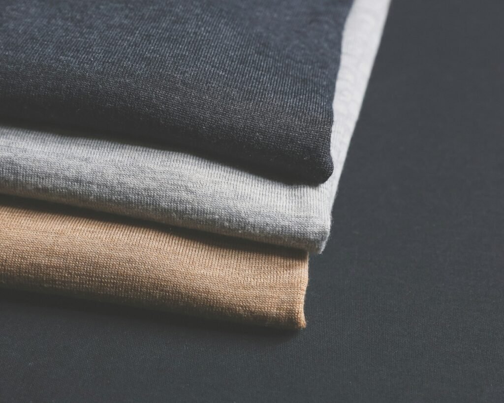 Folded charcoal, grey and tan garments
